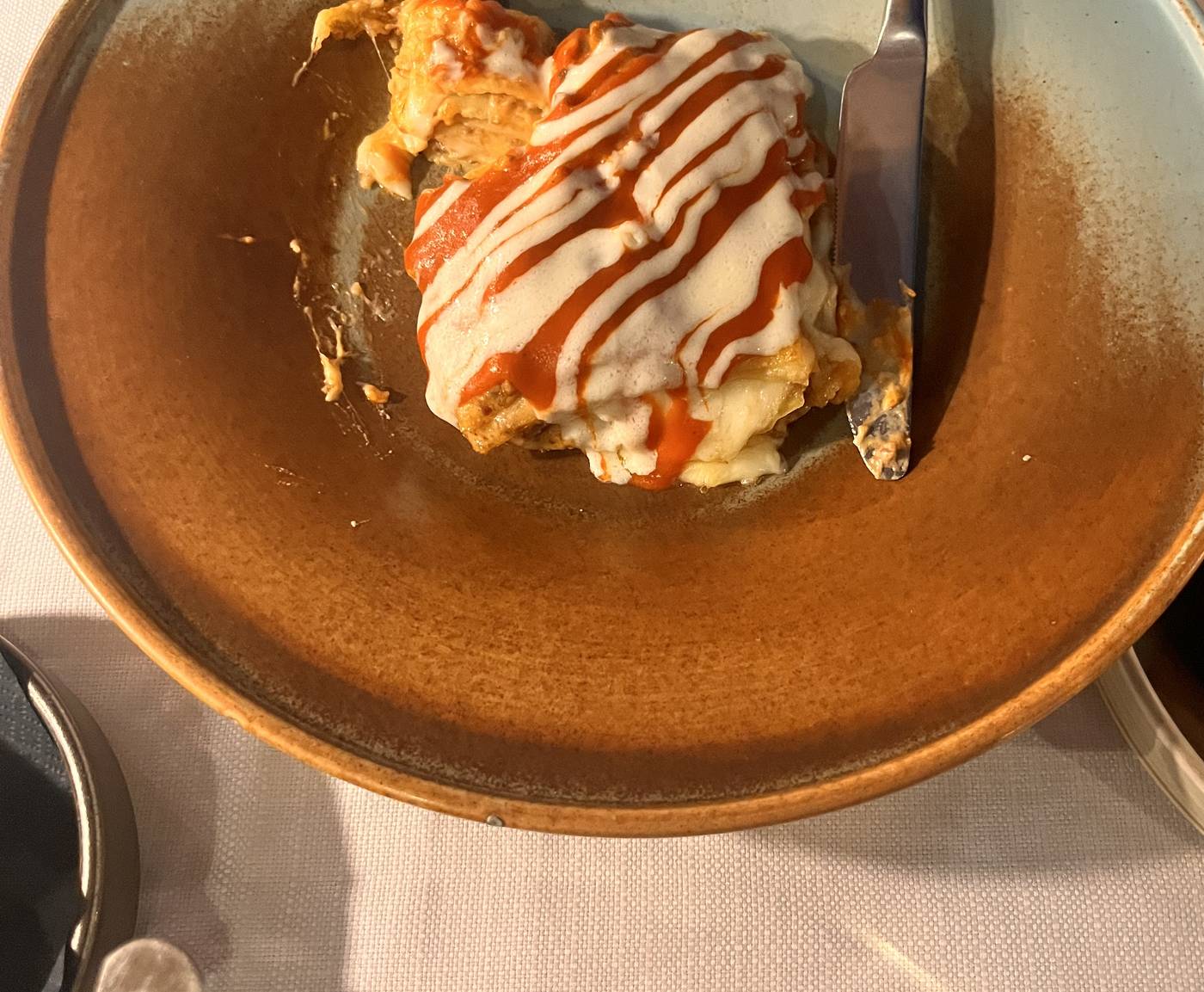 Il Tufo's elegant lasagne, layered under a white sauce with ribbons of tomato, in a terracotta-rimmed bowl